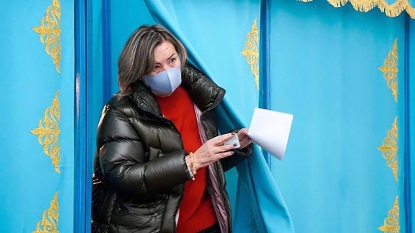 A woman leaves a voting booth to cast her ballot at a polling station in Almaty, Kazakhstan, Sunday, Nov. 20, 2022. — courtesy Vladimir Tretyakov/NUR.KZ