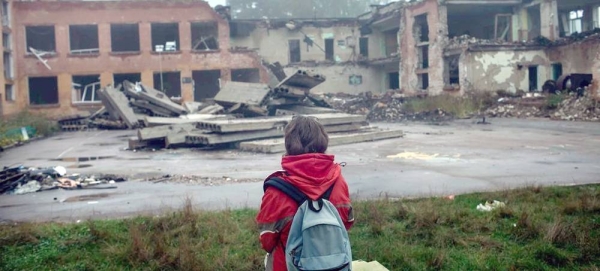 A child views devastated buildings during the war in Ukraine. — courtesy UNICEF / Diego Sanchez