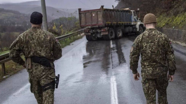 Nato-led Latvian soldiers in Kosovo inspect a truck blocking the way to the border with Serbia