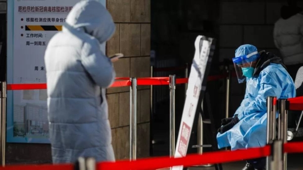 A volunteer health worker sits in front of the fever clinic at Chaoyang hospital in Beijing.