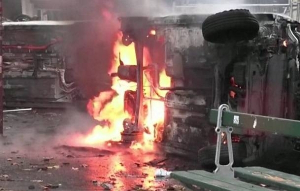 Firefighters extinguish burning cars following a day of unrest in Paris after Friday's deadly attack.