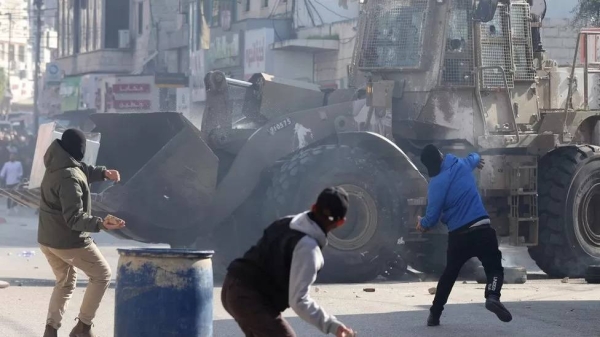 Palestinians throw stones amid clashes with Israeli troops during a raid in Jenin