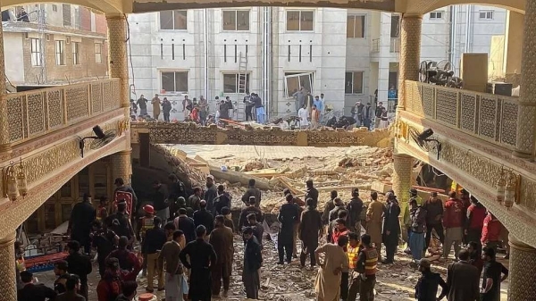 Police officers clear the route for ambulances carrying wounded people from the scene of blast.