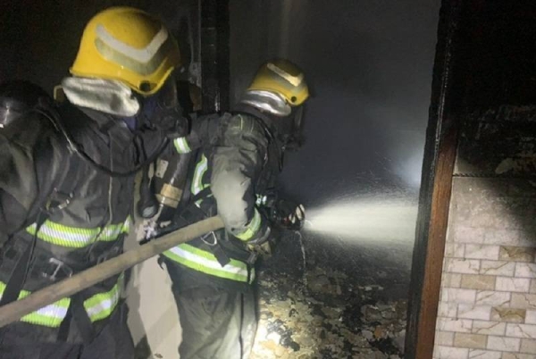 The Civil Defense personnel engage in rescue operations following a fire at a house in Al-Qurayyat. 