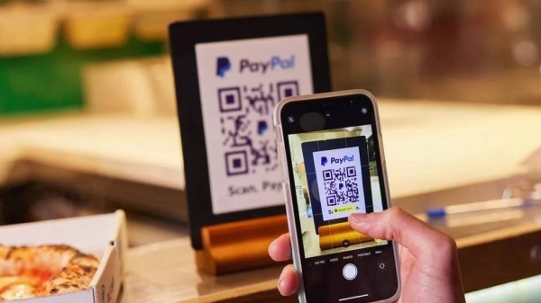 A person scans QR code with PayPal app.