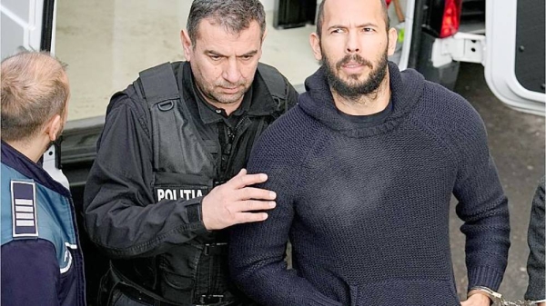 Police officers escort Andrew Tate, right, handcuffed to his brother Tristan Tate, to the Court of Appeal in Bucharest, Romania. — courtesy AP