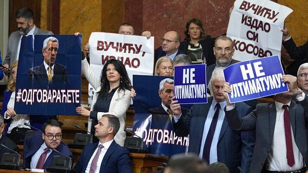 Serbian Lawmakers hold pictures of assassinated Kosovo Serb politician Oliver Ivanovic and banners that read, 'Not to the ultimatum' and 'Vucic, betrayed Kosovo'.