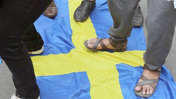 Activists step on the Swedish flag as demonstrators gather outside the Swedish Embassy in Jakarta on Jan. 30, 2023. — courtesy AFP