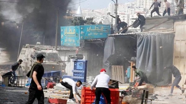 Palestinian youths threw stones and other objects at Israeli armored troop carriers during a raid in Nablus, in the occupied West Bank. — courtesy Reuters