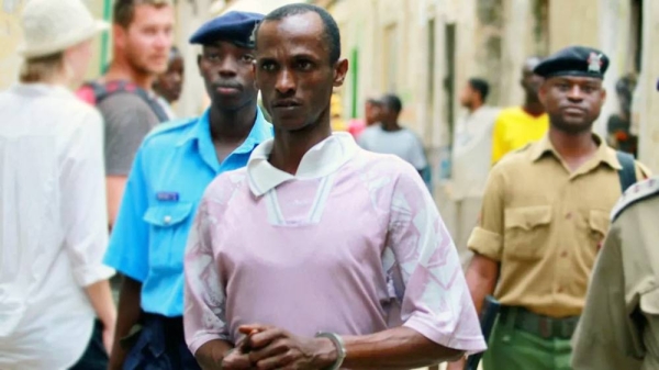 Ali Kololo, a former employee of the Kiwayu Safari Village, is escorted by police, July 2013. — courtesy Reuters