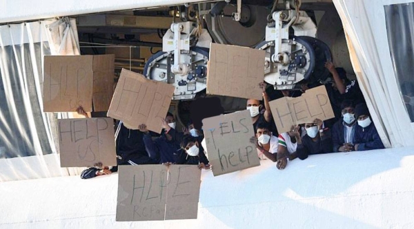 Migrants hold banners asking for help, from a deck of the Norway-flagged Geo Barents ship operated by Doctors Without Borders, in Catania’s port, Sicily in 2022.