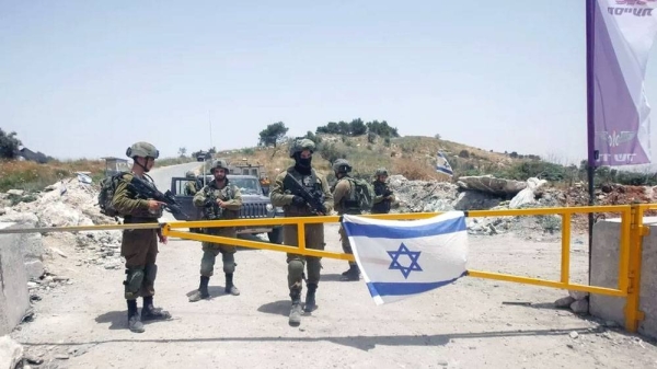 File photo showing Israeli soldiers guarding an entrance to the site of the evacuated settlement of Homesh (May 27, 2022). — courtesy SOPA Images