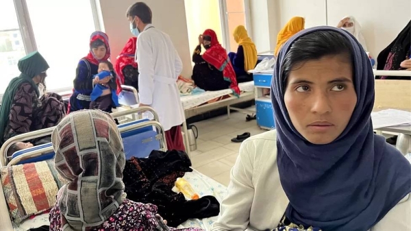 Tayabullah breathes oxygen through a tube held by his mother