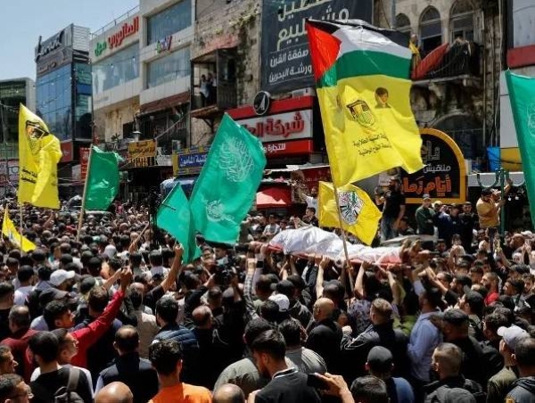 Mourners carry the body of a Palestinian man killed by Israeli forces in a raid on Nablus during his funeral