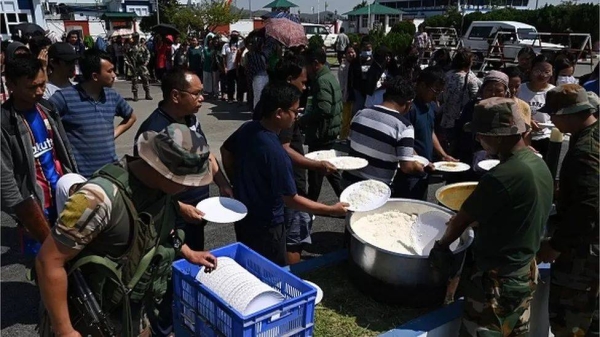 People fleeing ethnic violence wait at a temporary shelter in a military camp, after being evacuated by the Indian army