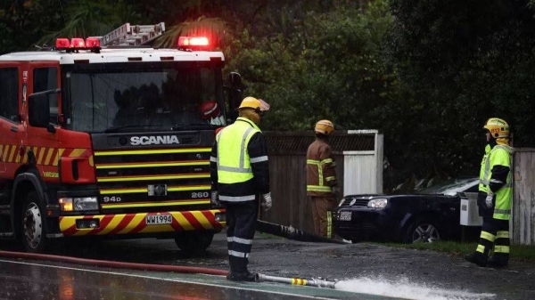 Firefighters pump water from a flooded home in Auckland