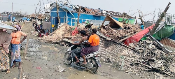 A motorbike travels through cyclone-damaged Thae Chaung IDP camp in Sittwe, Rakhine. — courtesy OCHA/Pierre Lorioux
