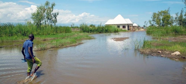 A man walks in floodwaters in Gatumba, Burundi an area which is receiving unpredictable rainfall due to climate change. — courtesy UNICEF/Karel Prinsloo