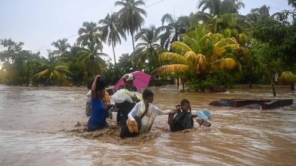 Residents cross the submerged Route Nationale 2, 37 km west of Port-au-Prince, Haiti