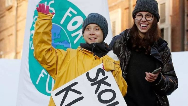 Greta Thunberg holds a sign reading, 'School strike for the climate' as she attends a climate march, in Turin, Italy, Friday 13 December 2019.