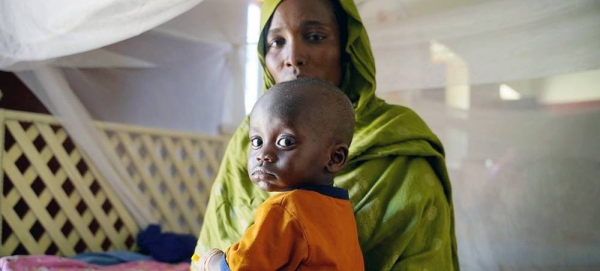 A mother brings her sick child to a UNICEF-supported health center in Northern Darfur, during the ongoing conflict in Sudan. — courtesy UNICEF/Mohamed Zakaria