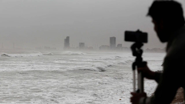 A man films the sea before the arrival of Biparjoy, at Clifton Beach in Karachi, Pakistan, on June 13