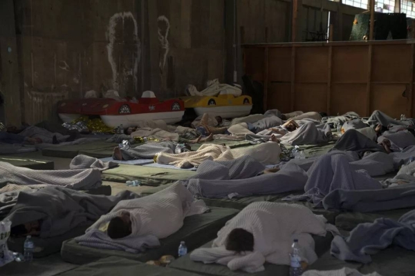Survivors of a shipwreck sleep in a warehouse at the port in Kalamata town, about 240 kilometers southwest of Athens, Greece. June 14