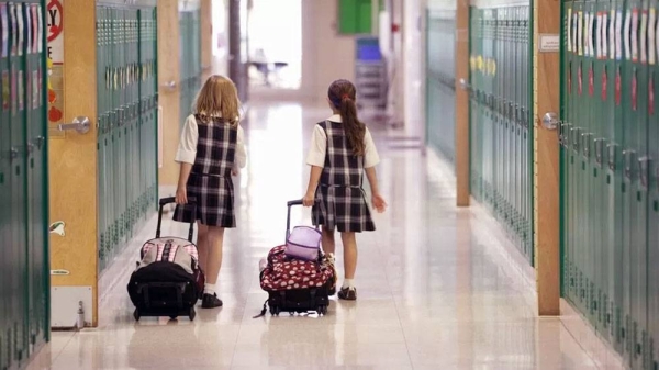 Two girls walk down a school hallway. — courtesy Getty Images