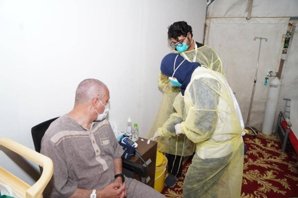 Health workers nursing a sick pilgrim in his camp in Mina. 