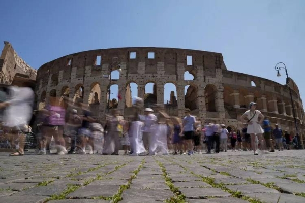 Visitors walk past the Colosseum, in Rome.