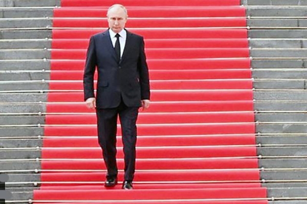 To the presidential fanfare Russian President Vladimir Putin descends the many steps of the Kremlin down onto the square.