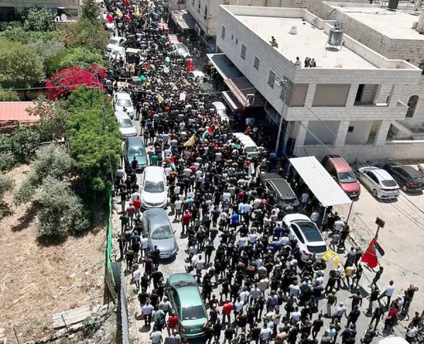 Screenshot shows thousands attending the funerals of the 12 Palestinians killed during the Israeli operation.