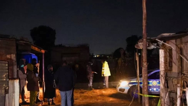 Police inspect the scene of a suspected gas leak in Boksburg's Angelo shanty town.