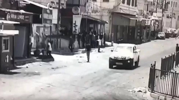 One video shows a pick-up truck driving past Abdul Rahman Hardan, who is wearing a dark top and standing in the middle of the road, moments before he is shot dead in Jenin