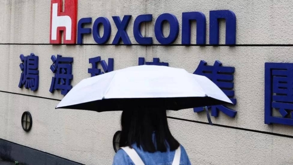 A woman carrying an umbrella walks past the Foxconn building in Taipei