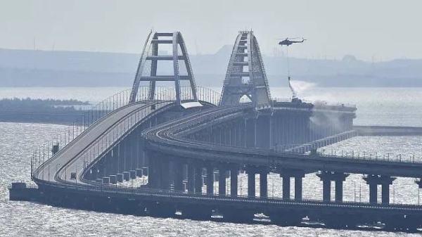 A helicopter drops water to stop fire on Crimean Bridge connecting Russian mainland and Crimean peninsula over the Kerch Strait, in Kerch, on Oct. 8, 2022.