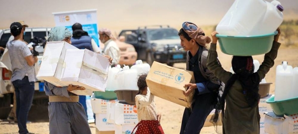 Children carry WFP food rations in a makeshift camp for displaced people in Marib, Yemen. — courtesy WFP/Abdullah Al-Garadi