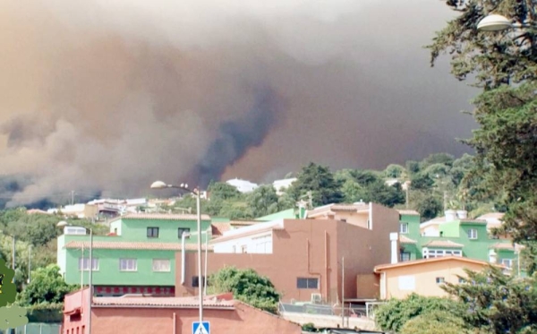 An aircraft drops water on the flames as the fire advances in Tenerife, Canary Islands, Spain.