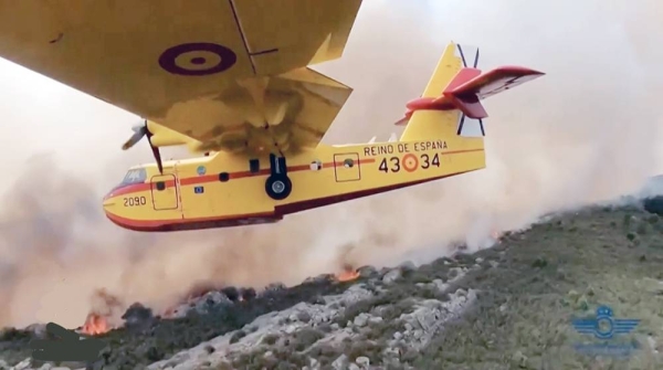 An aircraft drops water on the flames as the fire advances in Tenerife, Canary Islands, Spain.