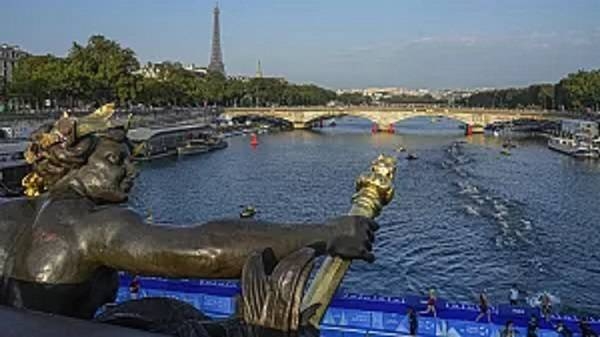 Athletes swim in the Seine river from the Alexander III bridge on the first leg of the women's triathlon test event for the Paris 2024 Olympics Games. 