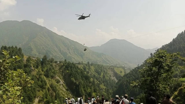 A soldier slings down from a helicopter during a rescue mission to recover students stuck in a cable car in Khyber Pakhtunkhwa province, Pakistan on August 22.
