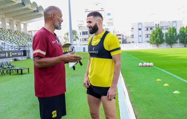 Karim Benzema and coach Nuno Santo having a conversation during a training session.