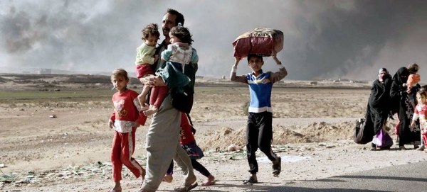 A newly displaced man carries two children at a check point in Qayyara, south of Mosul, Iraq. (file). — courtesy UNICEF/Alessio Romenzi