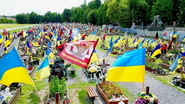 Flags fly above soldiers' graves in a cemetery in Lviv