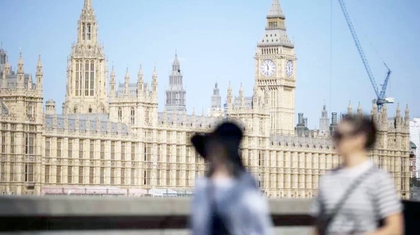 People walk along the Southbank with The Palace of Westminster, home to the Houses of Parliament, in the background in London, Britain. — courtesy EPA