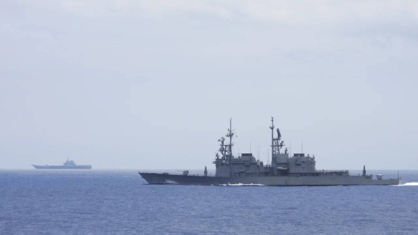 This photo released by Taiwan's Ministry of National Defense shows a Taiwanese navy ship monitoring the Chinese aircraft carrier, the Shandong, in waters near Taiwan.