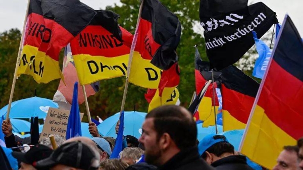 Protesters hold German flags with 'We are the people' written on them during a rally of far-right groups in Berlin
