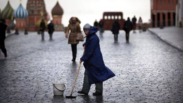 A street worker cleans paving stones in Red Square in Moscow, Russia