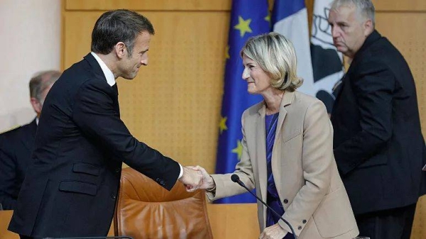 Emmanuel Macron shakes hands with the President of the Corsican Assembly Marie-Antoinette Maupertuis before addressing a session of the Corsican Assembly in Ajaccio