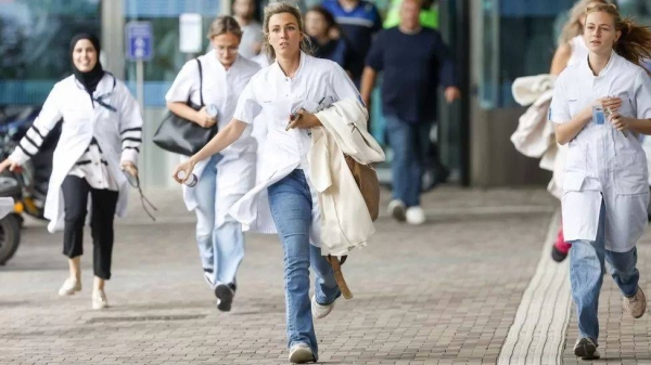 Employees seen running out of the Erasmus Medical Center after it was stormed by the gunman.